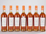 six bouteilles de whisky alignées sur une surface blanche