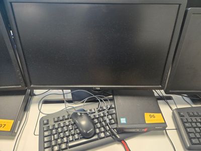 trois écrans d'ordinateur et un clavier posés sur un bureau