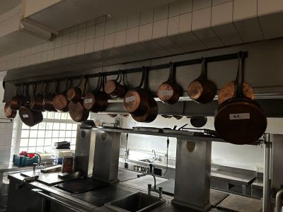 pots hanging from the ceiling in the kitchen of a restaurant