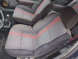 two seats in the front of a car with red stitching