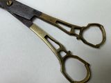 two pairs of scissors sitting on a white surface