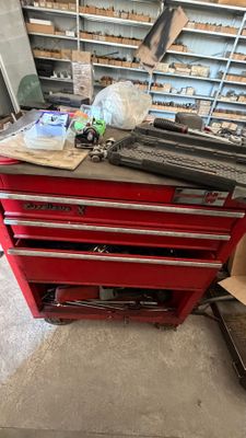 une boîte à outils rouge sur laquelle se trouvent de nombreux outils