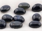 Plusieurs pierres noires sont disposées sur une surface blanche