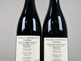 two bottles of wine sitting next to each other on top of a table