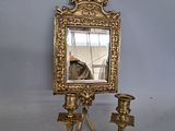 un miroir accroché au mur et un bougeoir accroché au mur