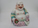 une figurine représentant un Bouddha rieur assis par terre