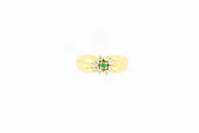 une bague en or jaune sertie d'une émeraude et de diamants