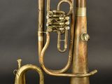 an old brass trumpet and a brass bell on a black background