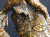 bronze sculpture of a man holding his head in his hands