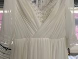 a white dress hanging on a rack in a store