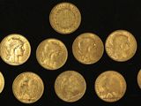 six different types of gold coins on a black surface