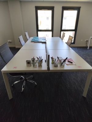 a long table with a bunch of pens and pencils on it