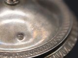 a silver plate with a lid on a table