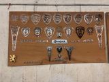 une plaque en bois sur laquelle sont fixés plusieurs insignes