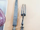 two knives and a piece of meat on a plate