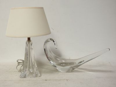 une lampe et un oiseau en verre posés sur une table