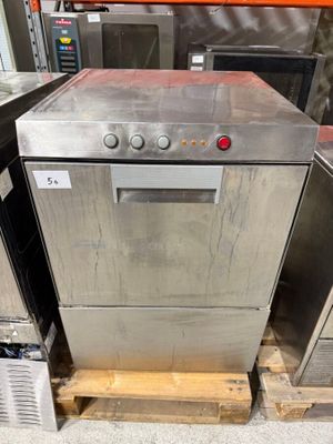 silver dishwasher sitting on pallets in a kitchen with other appliances