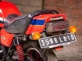 a red motorcycle parked in front of a brick wall