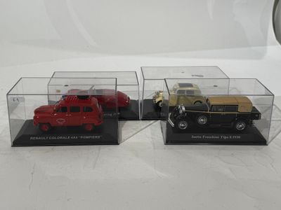 three model cars are in a display case on a white surface