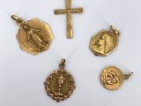 a group of gold religious charms including a cross, a medal, and a medal