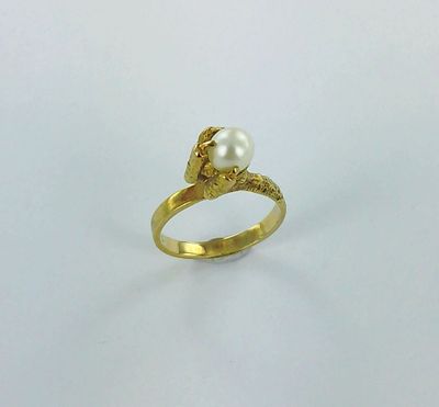 a close up of a gold ring with a pearl on it