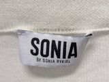 the label of a white sweater with a black and white logo