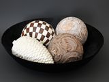 a black bowl filled with different types of decorative objects