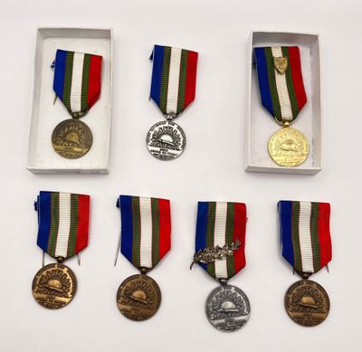 several medals are displayed in a display case on a white surface