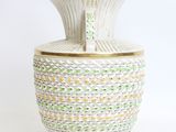 a white vase with green and yellow designs on it