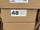 Plusieurs cartons sont empilés les uns sur les autres dans un magasin