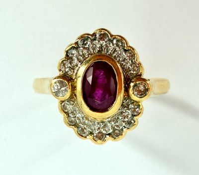 an image of a gold ring with a purple stone surrounded by white diamonds