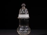 a clear glass jar with a lid on a black surface
