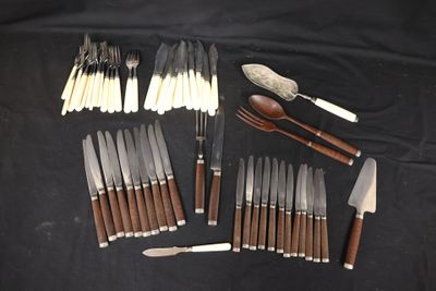 many different types of knives and spoons laid out on a table