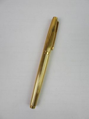an image of a gold pen on a white surface