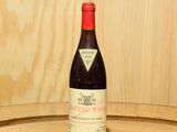 une bouteille de vin posée sur un tonneau en bois