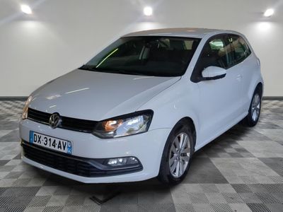 the white volkswagen polo is parked on a checkered tile floor
