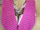 someone is wearing a pair of pink shoes on a wooden floor