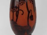 a brown vase with black designs on it on a stand