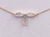 a gold necklace with three clear quartz beads on a gold chain
