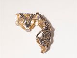 an image of a gold and black diamond ring on a white surface