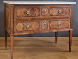 une commode au plateau en marbre posée sur une table en bois