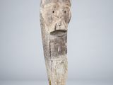 a sculpture of a man ' s head on a wooden base