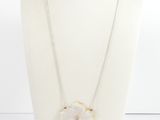 un collier blanc orné d'un pendentif en forme de fleur sur un mannequin