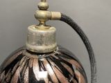 a black and gold vase with a metal hose attached to it