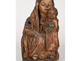 une vieille statue en bois représentant une femme tenant un enfant dans ses bras
