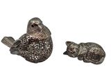 deux figurines en argent représentant des oiseaux perchés sur une branche