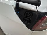a white car with an electric charger plugged into it