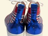 pair of red, white and blue shoes on a white surface