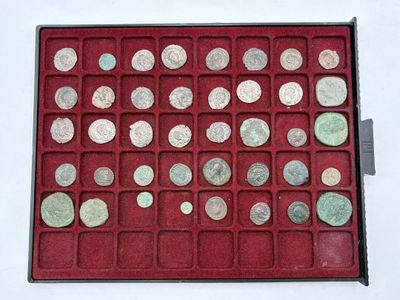 an assortment of silver and bronze coins in a red display case