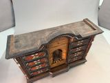 a small wooden cabinet with drawers and a door